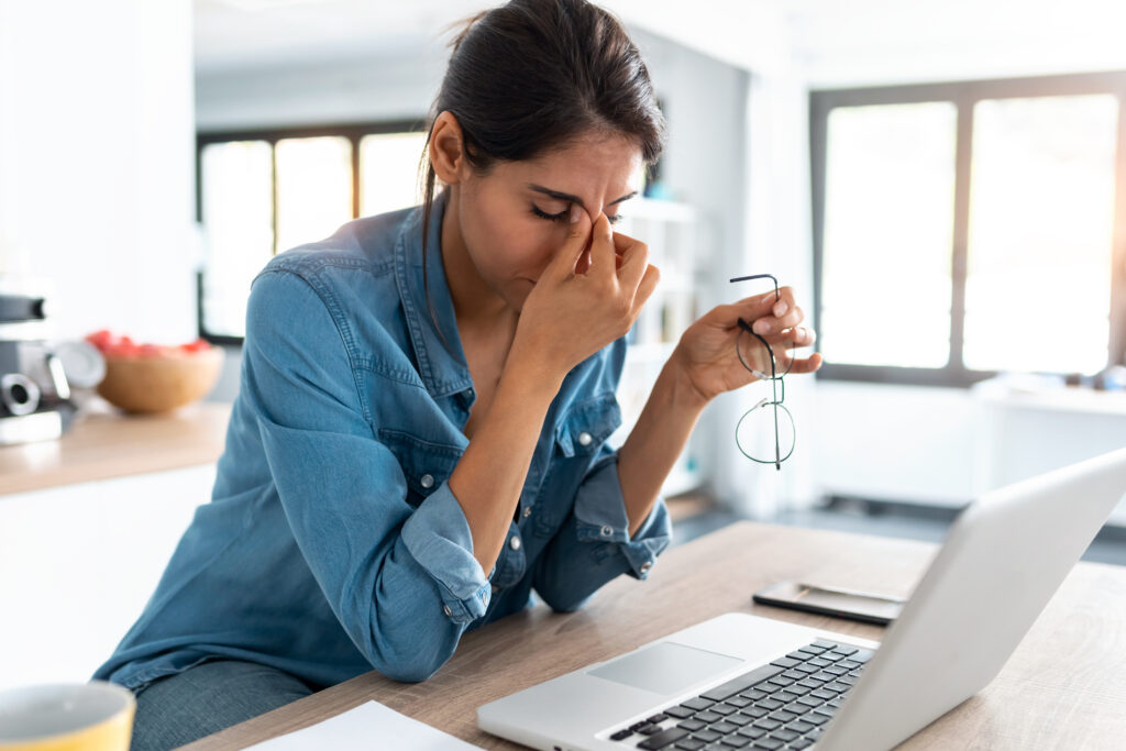 Stressed business woman working from home on laptop looking worr